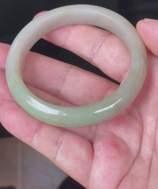 Video showcasing the natural glassy luster and fine crystalline texture of icy apple green, brown, and greyish milky white Burmese jadeite bangle JB091