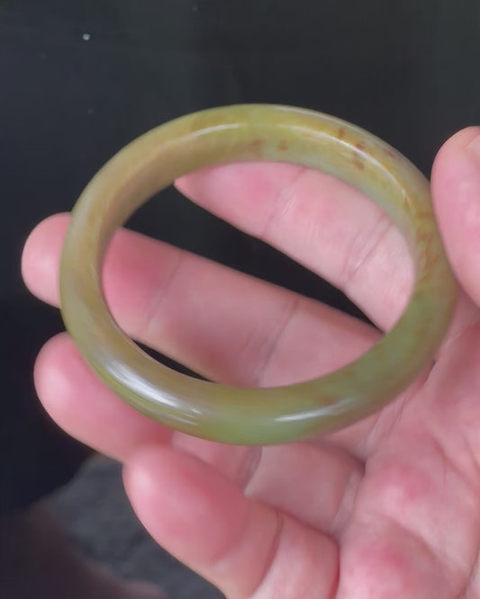 Video showcasing the vitreous luster and fine crystalline texture of icy apple green, moss green, and honey red Burmese jadeite bangle JB873