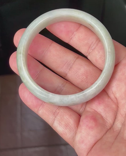 Video showcasing the natural glassy luster and fine crystalline texture of icy apple green and greyish hues Burmese jadeite bangle JB532