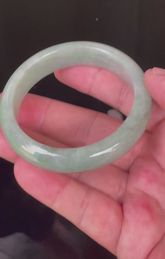 Video showcasing the bright glassy luster and fine crystalline texture of icy light bluish apple green and greyish milky white Burmese jadeite bangle JB034