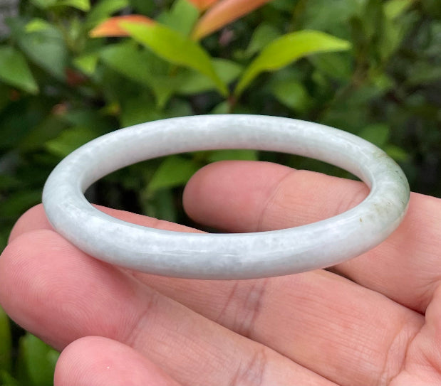 Solid icy milky white and moss green natural Type A Burmese jade bangle bracelet in size 55.9mm