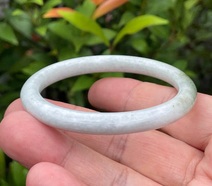 Solid icy milky white and moss green natural Type A Burmese jade bangle bracelet in size 55.9mm