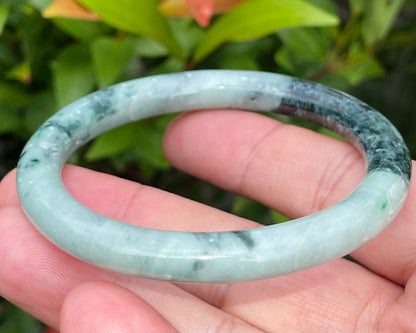 Solid bluish apple green and black natural Type A Burmese jade bangle bracelet in size 57mm