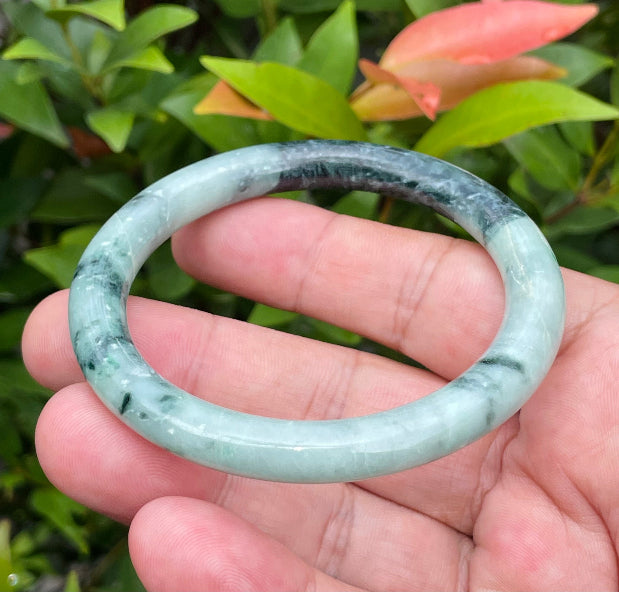 Solid bluish apple green and black natural Type A Burmese jade bangle bracelet in size 57mm