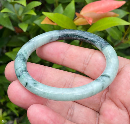 Solid bluish apple green and black natural Type A Burmese jade bangle bracelet in size 57mm