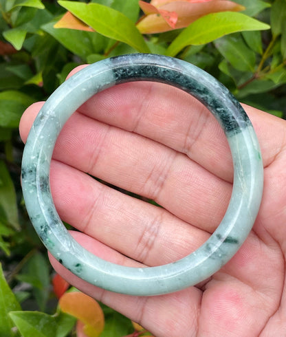 Solid bluish apple green and black natural Type A Burmese jade bangle bracelet in size 57mm