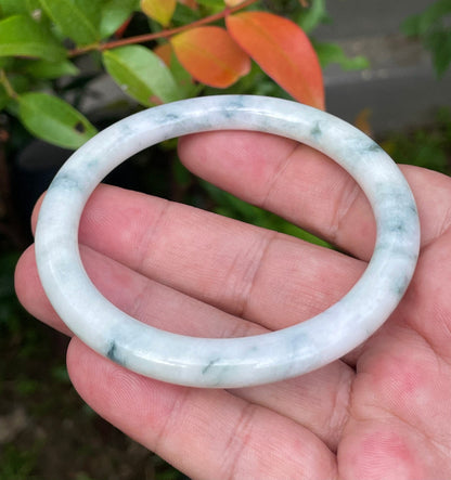 Solid icy imperial green and milky white natural Type A Burmese jade bangle bracelet in size 59mm