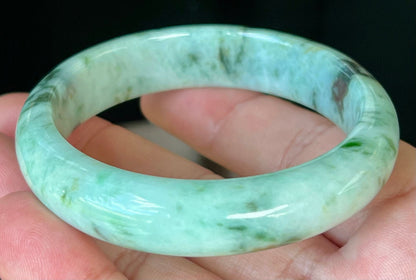 Rounded classic profile of 55.3mm icy green and black Burmese jade bangle JB543