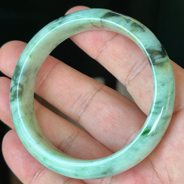 Rounded classic profile of 55.3mm icy green and black Burmese jade bangle JB543