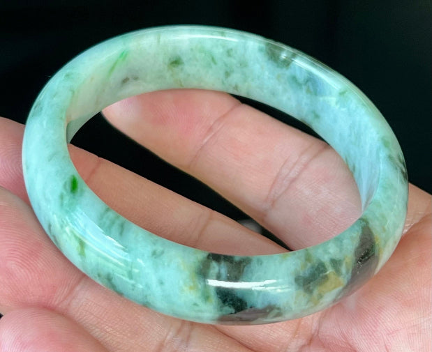 Rounded classic profile of 55.3mm icy green and black Burmese jade bangle JB543