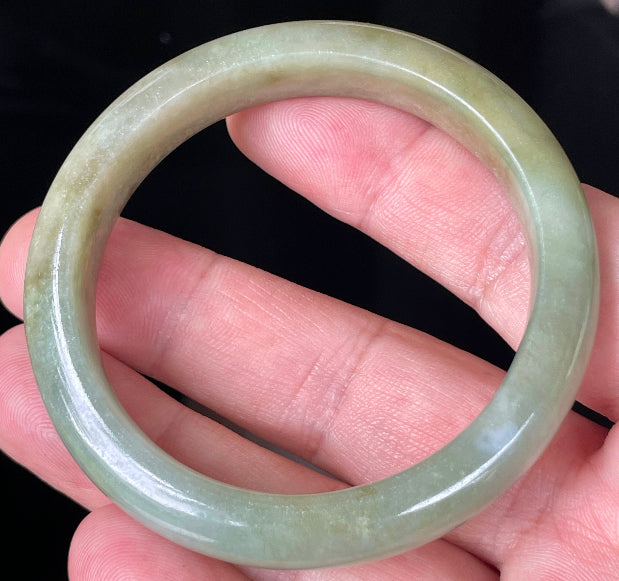 Rounded classic profile of 53mm icy apple green, white and honey brown Burmese jade bangle JB355