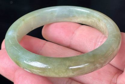 Rounded classic profile of 53mm icy apple green, white and honey brown Burmese jade bangle JB355