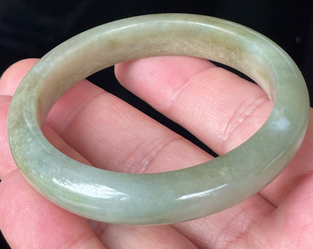 Rounded classic profile of 53mm icy apple green, white and honey brown Burmese jade bangle JB355