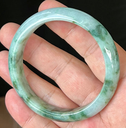 Rounded classic profile of 57.7mm icy apple green and black Burmese jade bangle JB561