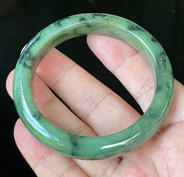 Flat inner and round outer edges of 58mm icy apple green and black floral Burmese jade bangle JB905