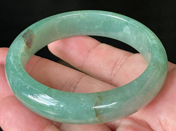 Flat inner and round outer edges of 58.4mm icy apple green, emerald green, and honey brown Burmese jade bangle JB906