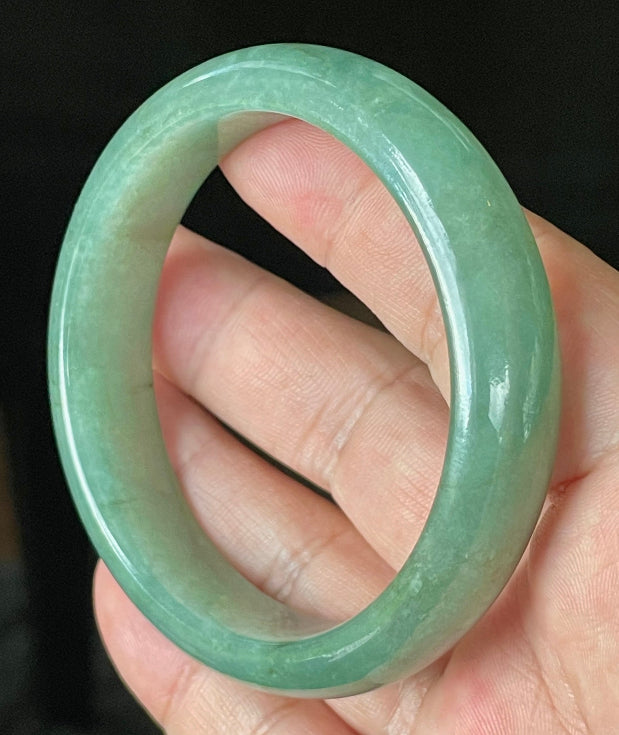 Flat inner and round outer edges of 58.4mm icy apple green, emerald green, and honey brown Burmese jade bangle JB906
