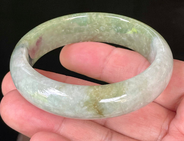 Flat inner and round outer edges of 54.8mm icy apple green, white, and black Burmese jade bangle JB050