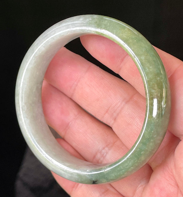 Flat inner and round outer edges of 54.8mm icy apple green, white, and black Burmese jade bangle JB050