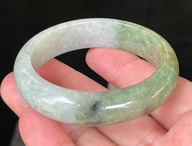 Flat inner and round outer edges of 54.8mm icy apple green, white, and black Burmese jade bangle JB050