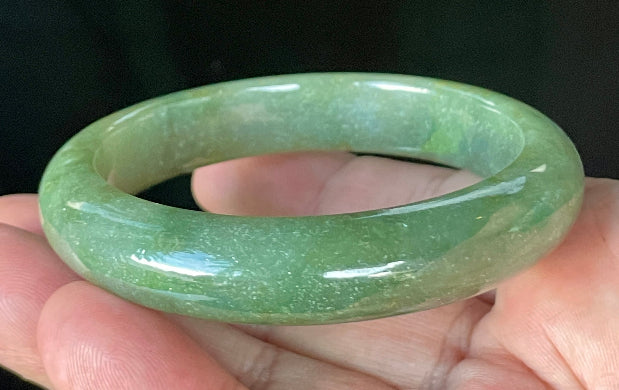 Flat inner and round outer edges of 57.6mm icy apple green, white, and honey Burmese jade bangle JB916