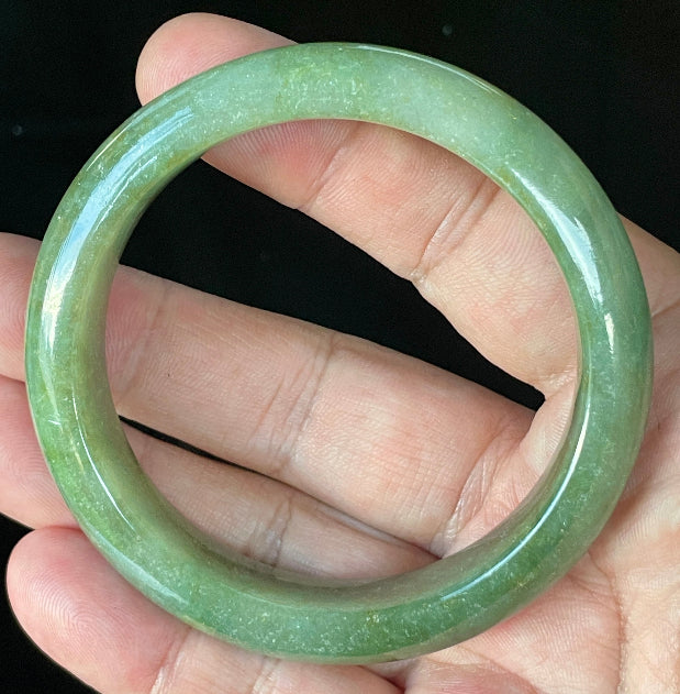 Flat inner and round outer edges of 57.6mm icy apple green, white, and honey Burmese jade bangle JB916