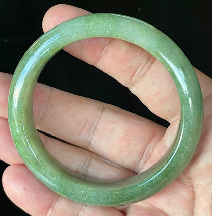 Flat inner and round outer edges of 57.6mm icy apple green, white, and honey Burmese jade bangle JB916