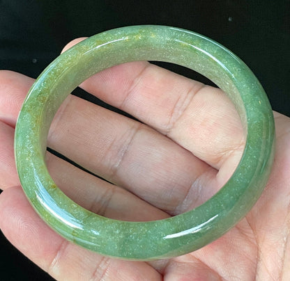 Flat inner and round outer edges of 57.6mm icy apple green, white, and honey Burmese jade bangle JB916