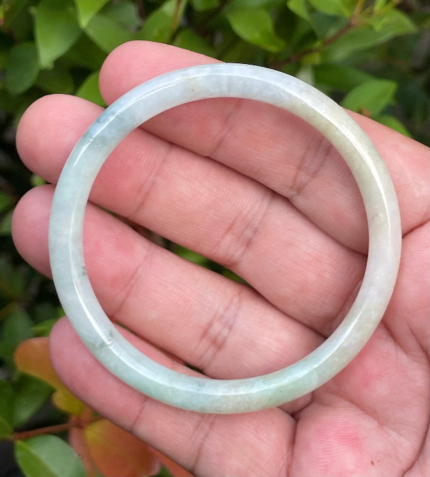 Slim profile icy white, bluish green, and gentle yellow natural Type A Burmese jade bangle bracelet in size 54.7mm