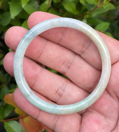 Slim profile icy white, bluish green, and gentle yellow natural Type A Burmese jade bangle bracelet in size 54.7mm