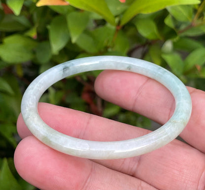 Slim profile icy white, bluish green, and gentle yellow natural Type A Burmese jade bangle bracelet in size 54.7mm