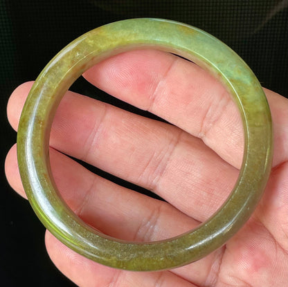 Flat inner and round outer edges of 55mm icy apple green, moss green, and honey red Burmese jade bangle JB873