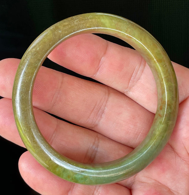 Flat inner and round outer edges of 55mm icy apple green, moss green, and honey red Burmese jade bangle JB873
