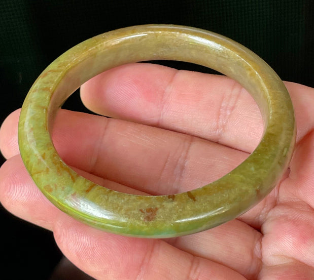 Flat inner and round outer edges of 55mm icy apple green, moss green, and honey red Burmese jade bangle JB873