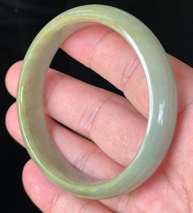 Flat inner and round outer edges of 59mm icy apple green and honey Burmese jade bangle JB213