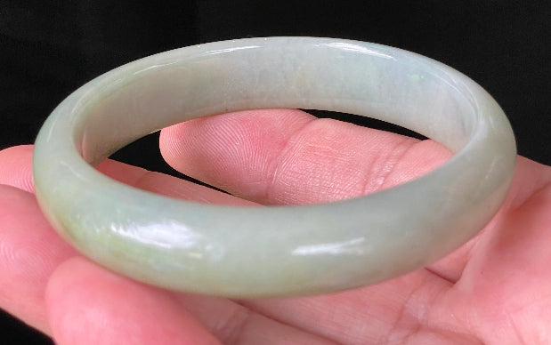 Flat inner and round outer edges of 59mm icy apple green and honey Burmese jade bangle JB213